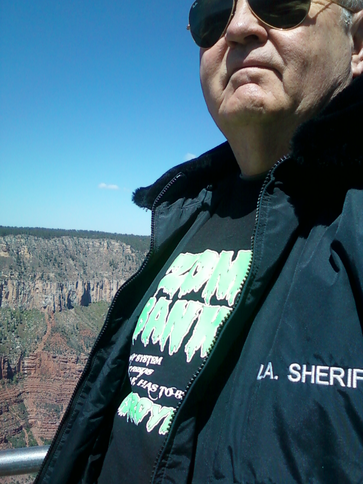 A man in black jacket standing on top of a mountain.